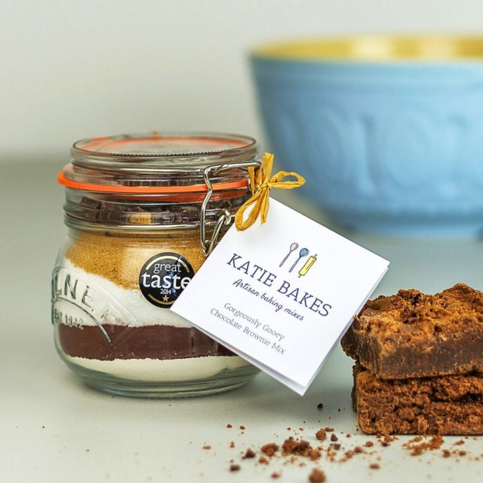 Gorgeously Gooey Chocolate Brownie baking Mix gift with ingredients layered in a kilner jar with baked brownies and a blue mixing bowl.