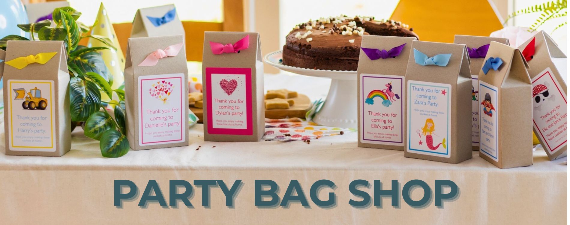 A birthday party table, with sustainable party favour boxes a birtday cake and party food. Party bags include favours for girls and boys parties.
