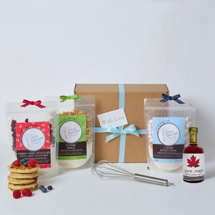 Luxury Pancake Lovers' Hamper box on white background with 3 pancake mixes, maple syrup, whisk and a stack of pancakes